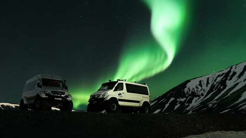 Arctic Explorer vehicles in the foreground, northern lights in the background - very clear sky