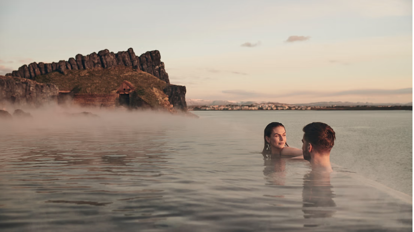 Couple enjoying the sunset in the infinity pool at Sky Lagoon