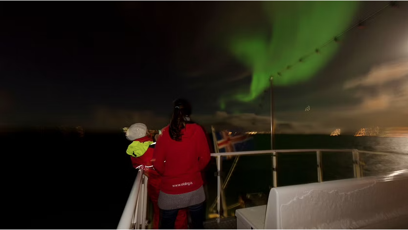 Tourists watching the northern lights from the deck of the cruise ship