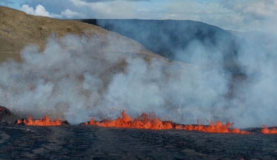 Lava erupting from the black volcanic ground during the 2023 Litla Hrut eruption
