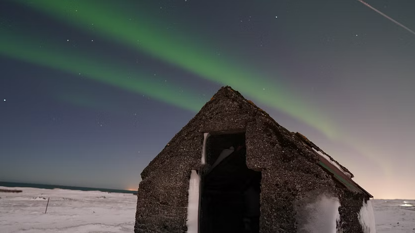 Aurora Borealis over an old countryside hut