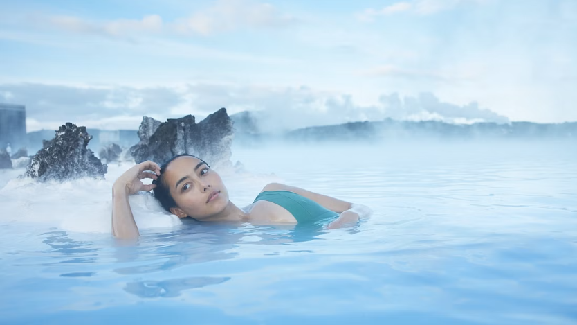 Young woman relaxing in the milky-blue steamy waters at the blue lagoon