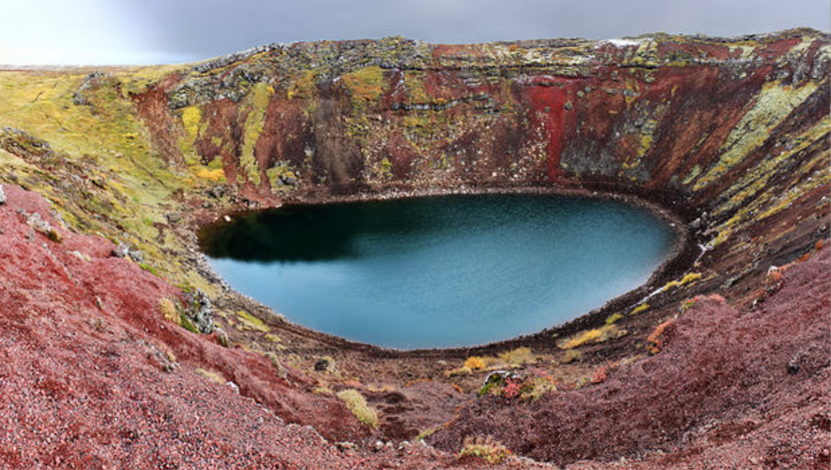 Kerid crater covered in Autumn vegetation, with its little pond at the bottom