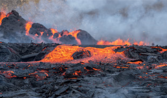 Red lava springing from the black ground at litla hrut during the 2023 volcanic eruption