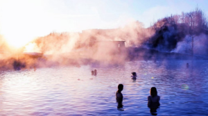 Golden Circle, secret lagoon & northern lights. Five people bathing in the steamy waters of the Secret Lagoon in the pinking daylight