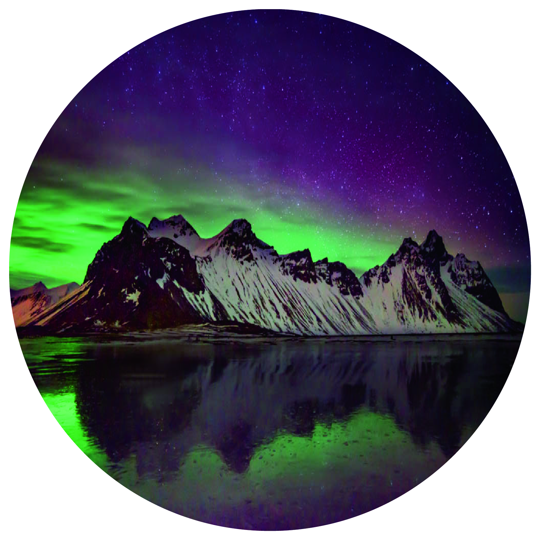 Purple and green northern lights reflect on the shoreline, with the mountain range covered in snow in backdrop