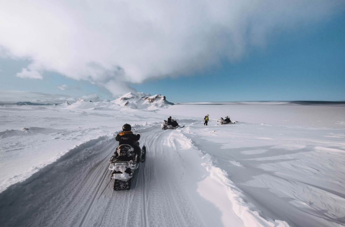 Snowmobiles driving on a snowy landscape on a glacier