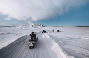 Snowmobiles driving on a snowy landscape on a glacier