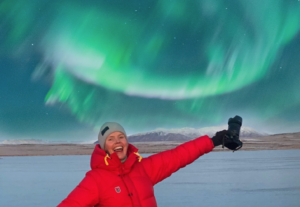 Photographer Katarina Raker posing under the northern lights