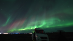 Minibus and northern lights above