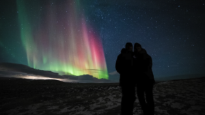 Couple under green and pink northern lights