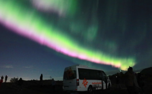 Northern lights over a minibus tour