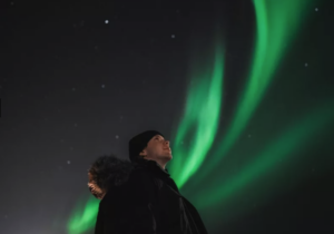 Traveller posing under the northern lights