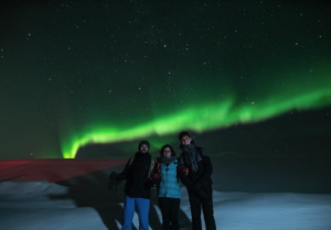 Family posing under the northern lights