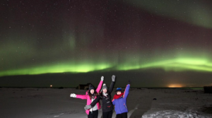 Visitors posing with the northern lights