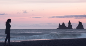 Visitor posing with sunset at black sand beach