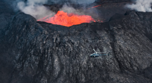 Helicopter flying next to volcano